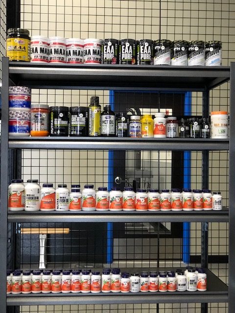 supplements on a shelf straight on - Train Hard Fitness 8180 Oswego Rd. Liverpool, NY 13090 315-409-4764
