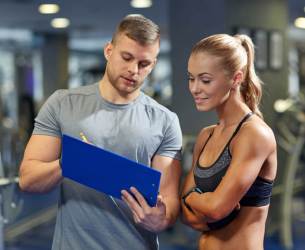 man and woman looking at a clipboard - Train Hard Fitness 8180 Oswego Rd. Liverpool, NY 13090 315-409-4764